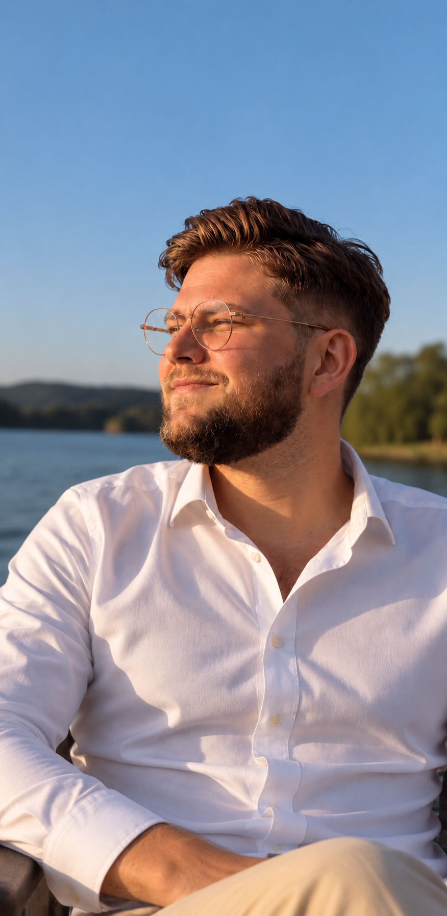 Kevin Maiworm im weißen Hemd im warmen Abendlicht am Wasser